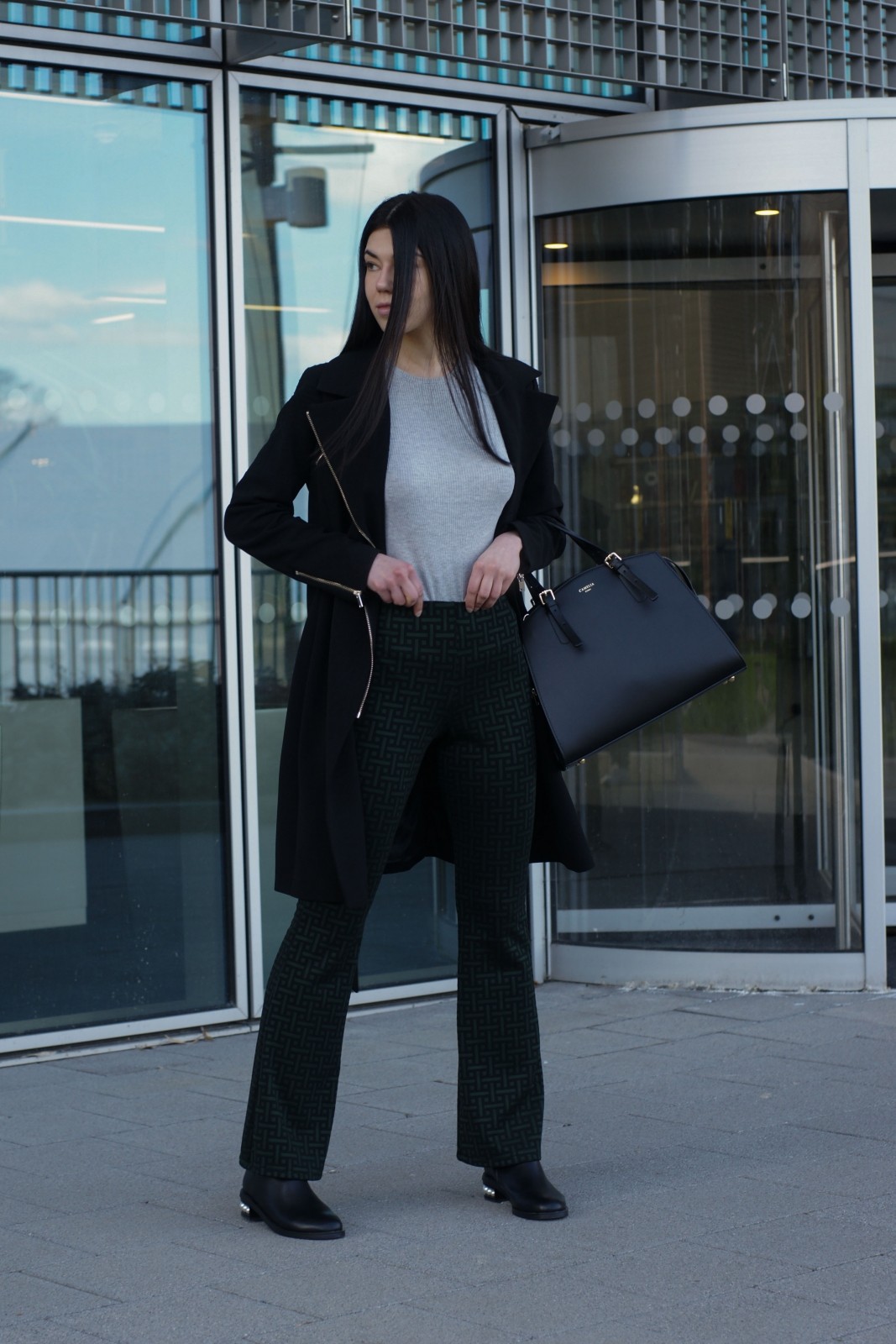 Brunette Fashion Blogger Wearing Black Trench Coat and Green Flared Trousers