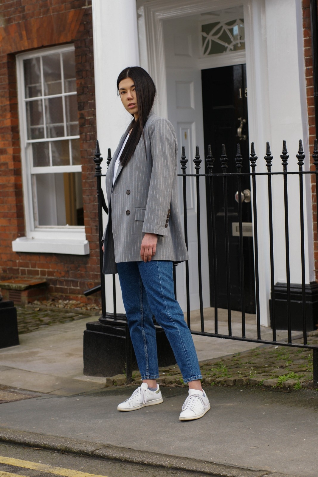 Brunette blogger with River Island suit blazer, jeans and trainers